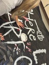 Lily painting Art Club sign for haunted trail