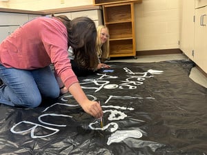 Keegan and Lily painting Art Club sign for haunted trail