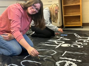 Keegan and Lily painting Art Club sign for haunted trail