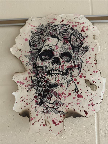 drawing of human skull with flowers and red/pink splatters